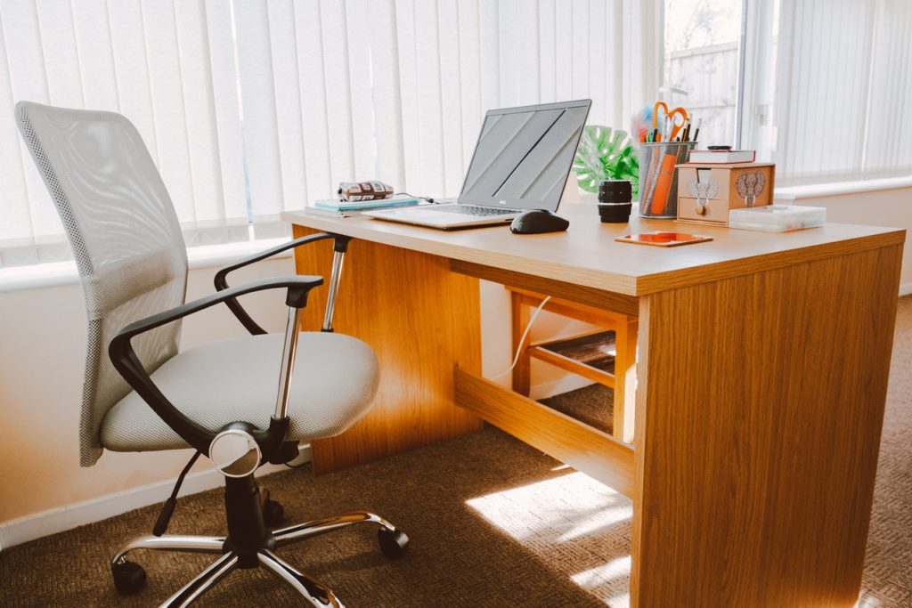 Wooden Office Desk, With a White Rolling Office Chair Nearby